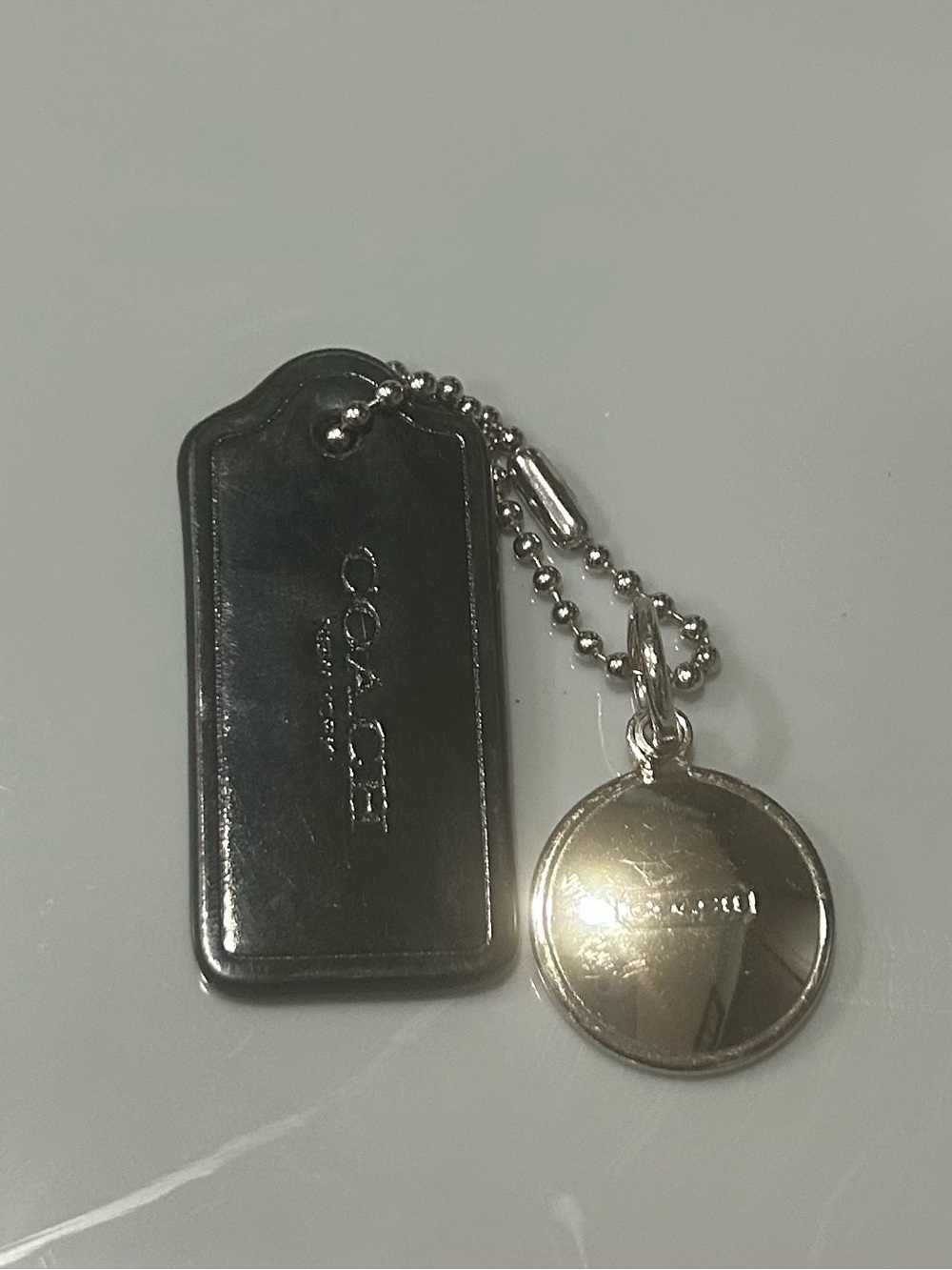 Coach Silver-Tone Round Toggle Key Charm with Black Leather Tag